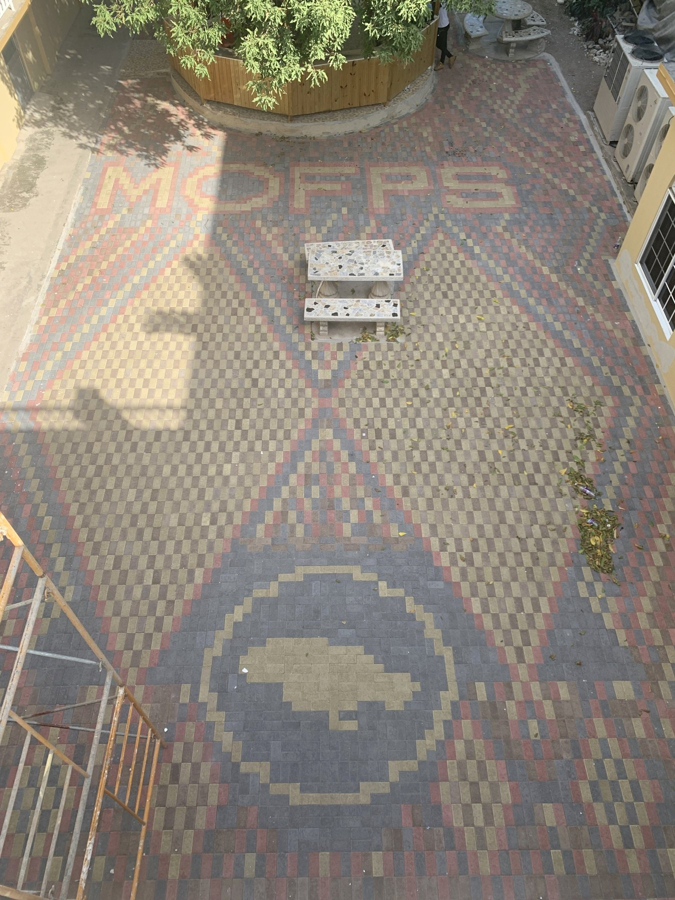 Custom interlocking brick courtyard with the MOFPS lettering and Jamaica motif.