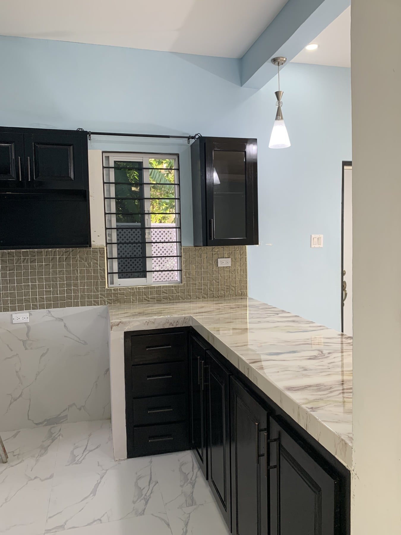 The veined epoxy peninsula and black cabinetry, with a clear view of the finished working surface.