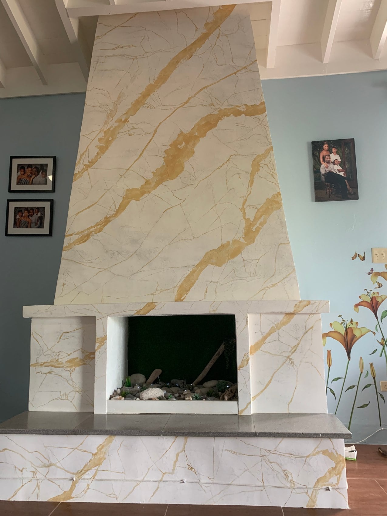 Tall white and gold marble-effect fireplace with a dark central opening