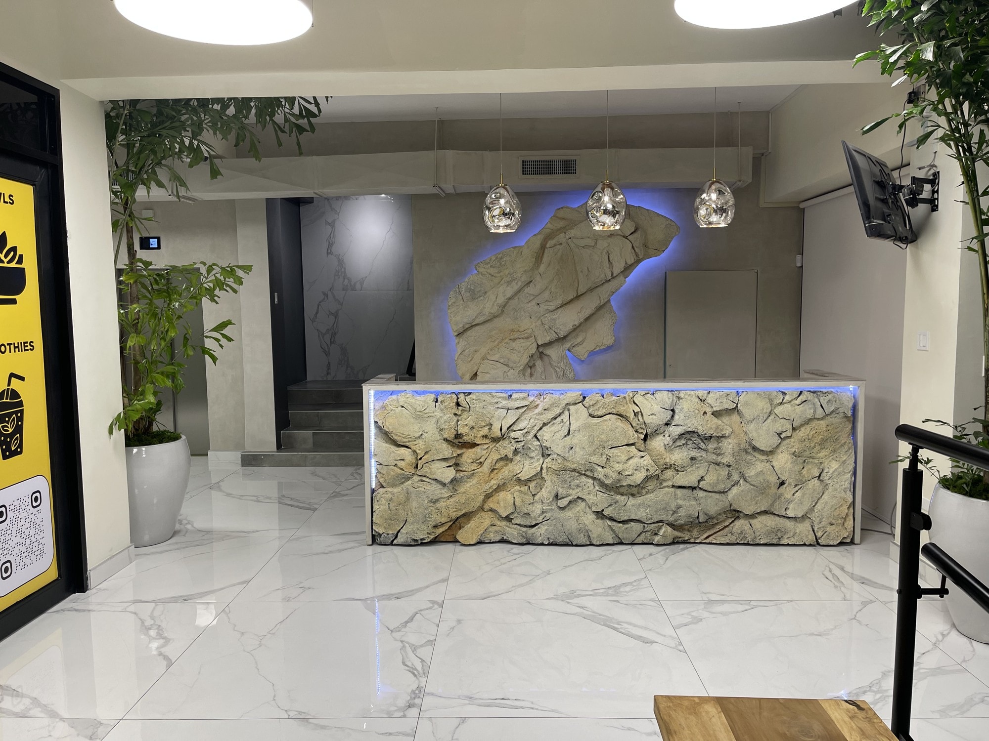 Completed reception with the stonewashed desk and wall sculpture both backlit