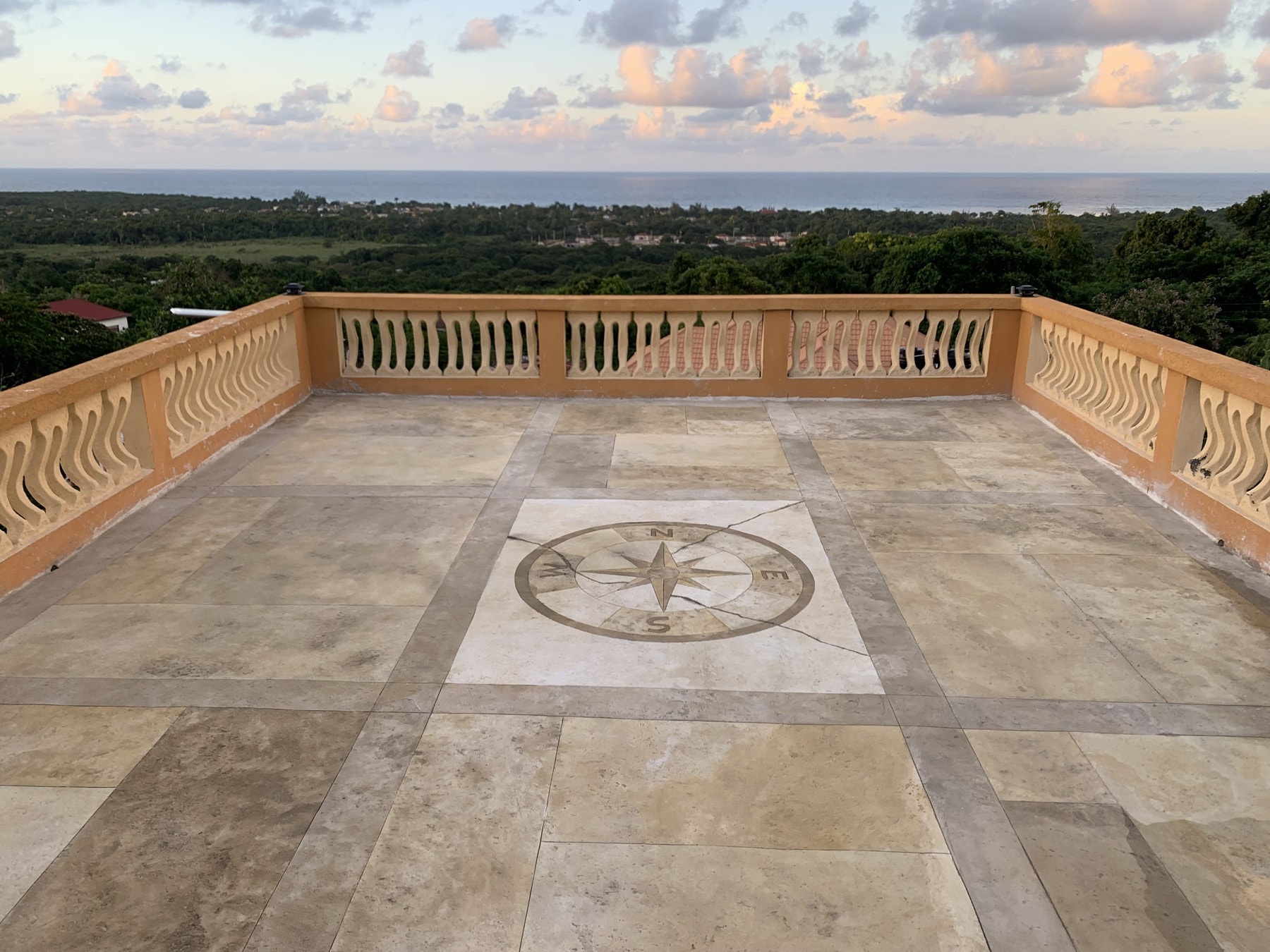 Travertine-textured concrete balcony with compass design